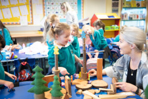 Teacher and student smiling at each other doing an activity together