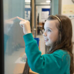 student interacting with digital whiteboard