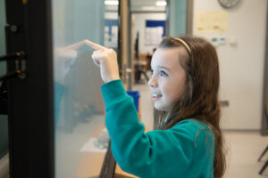student interacting with digital whiteboard